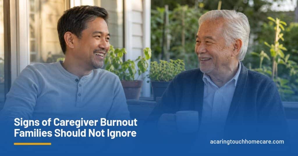 An adult son and his elderly father share tea and a laugh on a sunny back porch.
